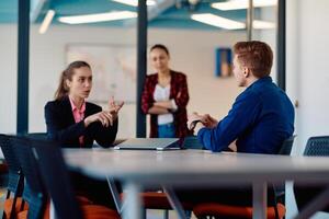 A team of successful programmers sits in a startup office, strategizing new business projects and solving existing challenges, showcasing innovation and collaboration in the tech industry photo