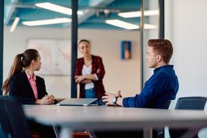 A team of successful programmers sits in a startup office, strategizing new business projects and solving existing challenges, showcasing innovation and collaboration in the tech industry photo