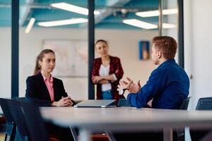 A team of successful programmers sits in a startup office, strategizing new business projects and solving existing challenges, showcasing innovation and collaboration in the tech industry photo