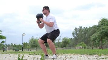 sports and leisure. strong Caucasian man working out using kettlebell in the park video