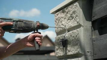 Builder Drills a hole in the wall with a Hammer Drill. Close-up of hammer drill perforator making hole video