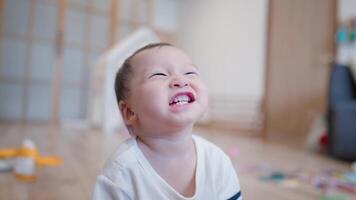 Close up Happy asian baby sitting inside the living room laughing and smiling while playing at home, Asian Toddler playing in the house living room and learns development skills, fully big smile video