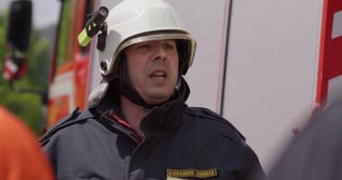 A close-up shot focuses on a firefighter's face as they discuss an evacuation plan, exemplifying their professionalism and dedication in ensuring the safety of people in a fire hazard area video