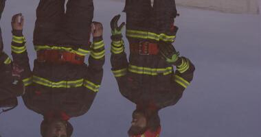 el reflexión en agua revela un equipo de especialmente equipado bomberos coordinando y embarcarse en un alto riesgo, salvavidas misión a rescate personas en angustia, exhibiendo su inquebrantable video