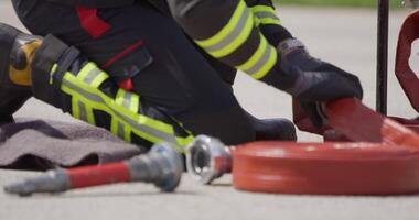 A team of firefighters swiftly readies water hoses, demonstrating their urgent response to prepare for a dangerous fire suppression mission, highlighting their commitment to firefighting and safety. video