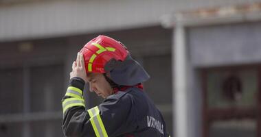 A firefighter removes their helmet after a dangerous rescue mission, symbolizing the end of a heroic effort to save victims from a fire, showcasing their dedication and sacrifice in the face of danger video