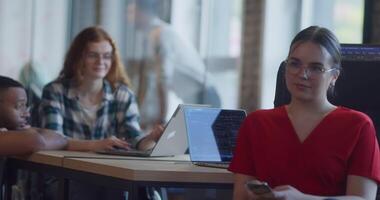 A diverse group of colleagues collaborates using laptops, mobiles, and tablets to tackle business challenges and enhance productivity through teamwork and innovative technology. video
