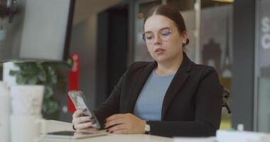 A disappointed woman in a wheelchair using a smartphone in a modern office, highlighting the importance of accessibility and inclusivity in the workplace, despite the challenges she faces video