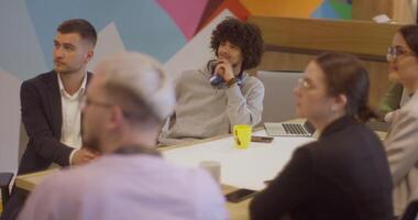 A diverse team of business experts in a modern glass office, attentively listening to a colleague's presentation, fostering collaboration and innovation video
