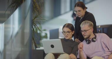 A diverse group of colleagues exchange business experiences, engage in collaborative problem-solving, and work together in a relaxed, modern office interior, demonstrating the value of teamwork and video