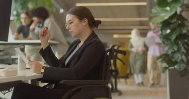 A businesswoman in a wheelchair is seen working on a laptop in a modern office, exemplifying a workplace that values inclusivity, accessibility, and professionalism. video