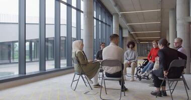 A diverse group of young business entrepreneurs gathered in a circle for a meeting, discussing corporate challenges and innovative solutions within the modern confines of a large corporation video