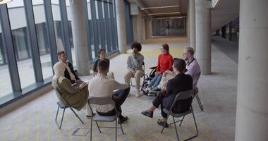A diverse group of young business entrepreneurs gathered in a circle for a meeting, discussing corporate challenges and innovative solutions within the modern confines of a large corporation video