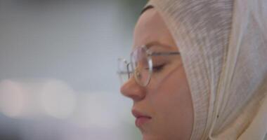 A businesswoman in a hijab is seen working on a computer in a modern office, highlighting inclusivity and professionalism in a diverse workplace video