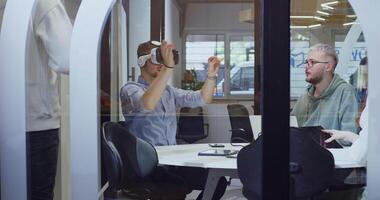 A diverse group of businessmen collaborates and tests a new virtual reality technology, wearing virtual glasses, showcasing innovation and creativity in their futuristic workspace video