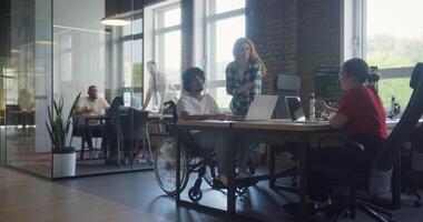 A diverse group of business colleagues engage in discussions about various business challenges, surrounded by their coworkers in a modern startup office, showcasing teamwork, innovation, and problem video