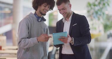 In a modern office setting, an African American businessman engages in a discussion with his director, using a tablet to address business challenges, symbolizing collaboration and technology video