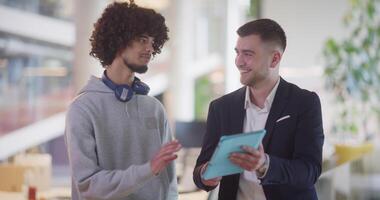 i en modern kontor miljö, ett afrikansk amerikan affärsman engagerar i en diskussion med hans direktör, använder sig av en läsplatta till adress företag utmaningar, symboliserar samarbete och teknologi video