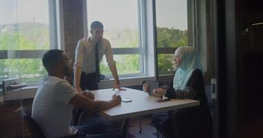 A diverse group of business colleagues engage in discussions about various business challenges, surrounded by their coworkers in a modern startup office, showcasing teamwork, innovation, and problem video