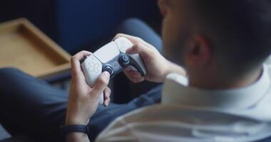 A business company's director takes a break from work in a modern office and indulges in gaming, using a joystick to play games on a TV, combining leisure and relaxation with a dash of office video