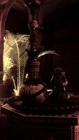 A room with candles and a table with a vase on it video