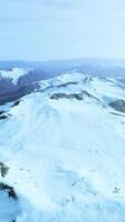 large snow patch left over on the volcanic rock field of a mountain in summer video