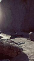 Rugged rock cliff with mountains in the ocean video