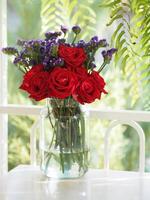 Red rose and Dried statice flower soft pink, violet color in clear glass vase vintage style, Concept for write text design in front background photo