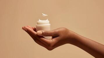 Mock-Up of Hand Holding Cream Jar with Floating Cream on Beige Background - Beauty and Cosmetics Product photo