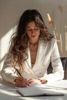Young Woman Writing in Notebook at Desk photo