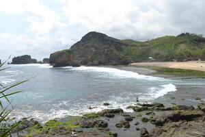 View of sea and rocks at Siung beach photo