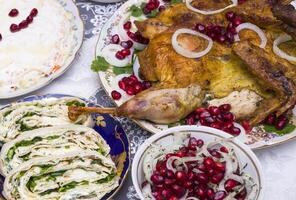 Different food on a wooden table, grilled chicken legs, buffalo wings, salad, photo
