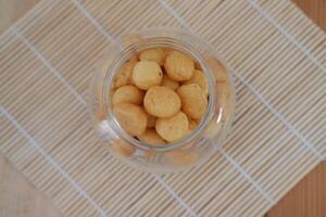 a traditional cake from Indonesia called kue sus filled with cream puffs. served on jar photo