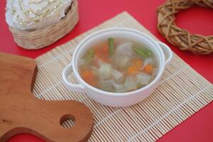 A bowl of vegetable soup on a table photo