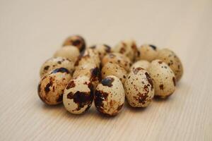 Quail eggs on a wooden background. Close-up, selective focus. photo