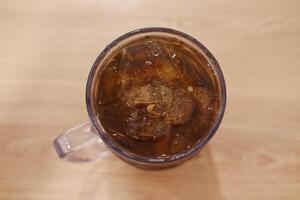 Ice tea in glass on wooden table. Selective focus and shallow depth of field. photo