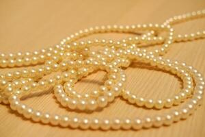 Pearls arranged neatly on a rustic wooden table photo