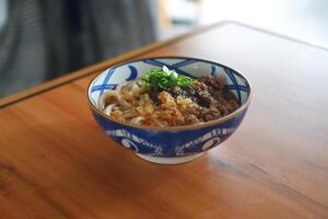 japan style noodles with beef and vegetables on wooden table. photo