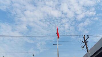 Indonesian flag on pole with blue sky background photo