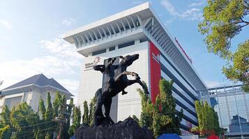 Semarang, Indonesia - February, 2024 - The statue of Prince Diponegoro riding a horse is located on Jalan Imam Bardjo, Semarang City, with the Telkom building in the background photo