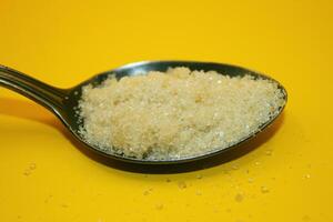 sugar in a spoon, sugar on a yellow background, sugar photo