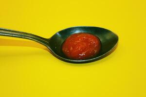 red tomato sauce in spoon, red sauce with yellow color lat photo