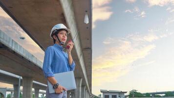 Asian female team leader wearing white safety fog Radio commands are being used in places, concrete roads, highway bridges. photo