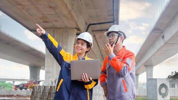 Asian engineering team Inspecting construction work radio command concrete road bridge highway photo