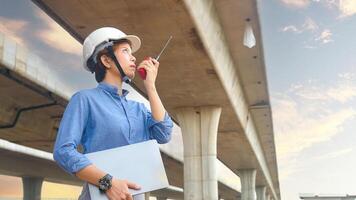 Asian female team leader wearing white safety fog Radio commands are being used in places, concrete roads, highway bridges. photo