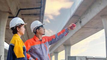 Asian engineering team Inspecting construction work radio command concrete road bridge highway photo