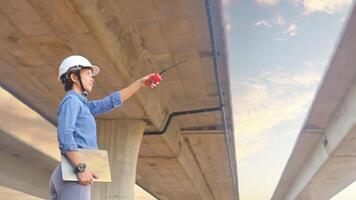Asian female team leader wearing white safety fog Radio commands are being used in places, concrete roads, highway bridges. photo