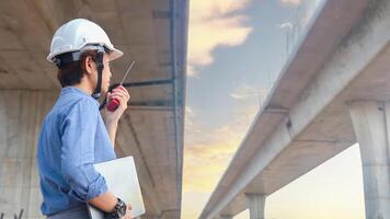 Asian female team leader wearing white safety fog Radio commands are being used in places, concrete roads, highway bridges. photo