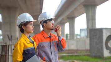 Asian engineering team Inspecting construction work radio command concrete road bridge highway photo