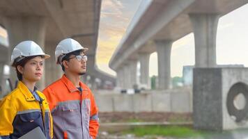 Team of Asian engineers inspecting concrete road construction, highway bridge, teamwork concept. photo